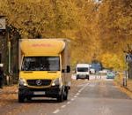 DHL van driving through a scenic autumn street in Jönköping, Sweden.